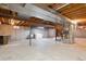 Unfinished basement with exposed beams, concrete walls and floors and laundry area at 4192 S Vrain St, Denver, CO 80236