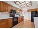 Traditional-style kitchen features wood cabinets, black appliances, and a unique coffered glass ceiling at 4192 S Vrain St, Denver, CO 80236