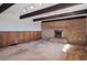 Bright living room featuring a brick fireplace, exposed beams, and paneled accent walls at 4192 S Vrain St, Denver, CO 80236