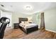 Bedroom featuring wood flooring, a large bed with side tables, and a window overlooking the yard at 7350 W 21St Ave, Lakewood, CO 80214
