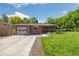 A well-maintained brick house with a green lawn, garage, and inviting front entrance at 7350 W 21St Ave, Lakewood, CO 80214