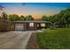Charming brick home with a well-manicured lawn and an attached one-car garage and beautiful sunset at 7350 W 21St Ave, Lakewood, CO 80214