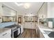 Open concept kitchen with stainless steel range, granite counters, light wood floors, and adjacent dining area at 7350 W 21St Ave, Lakewood, CO 80214