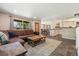 Open-concept living room with hardwood floors, a dining area, and a view into the kitchen at 7350 W 21St Ave, Lakewood, CO 80214