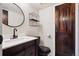 Stylish bathroom with black fixtures and rustic wood door at 7705 W 87Th Dr, Arvada, CO 80005