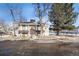 Exterior view of a townhome featuring mature trees and a community pool area in the background at 7705 W 87Th Dr, Arvada, CO 80005