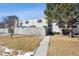 Charming townhome featuring a fenced front yard with mature trees and a walkway leading to the entrance at 7705 W 87Th Dr, Arvada, CO 80005