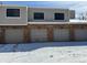 Garage row with red brick and grey doors offers convenient parking at 7705 W 87Th Dr, Arvada, CO 80005