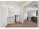 Hallway view leading to a bedroom, featuring carpeted floors and black railing at 7705 W 87Th Dr, Arvada, CO 80005