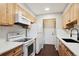 Efficient kitchen with white appliances, light wood cabinets, and white subway tile at 7705 W 87Th Dr, Arvada, CO 80005