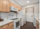 Efficient kitchen with white appliances, tile backsplash, and ample cabinet space at 7705 W 87Th Dr, Arvada, CO 80005