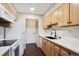 Compact kitchen with white appliances, ample light wood cabinetry, and a stylish black faucet at 7705 W 87Th Dr, Arvada, CO 80005