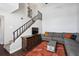 Cozy living room with dark wood floors, comfortable seating, and staircase at 7705 W 87Th Dr, Arvada, CO 80005