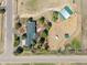 An aerial view displays the house and barn with green roofs, a trailer and metal outbuilding on a dry lot at 12160 Spring Creek Rd, Parker, CO 80138