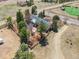This aerial shows a house and a barn along a country road with a horse in a distant pasture at 12160 Spring Creek Rd, Parker, CO 80138