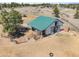 Aerial view showcasing a barn with an attached shed and gated access at 12160 Spring Creek Rd, Parker, CO 80138