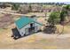 Aerial view of a white and green barn with a spacious design, suitable for various livestock at 12160 Spring Creek Rd, Parker, CO 80138