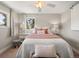 Cozy bedroom with plush bedding, decorative pillows, and an accenting ceiling fan with lighting at 12160 Spring Creek Rd, Parker, CO 80138