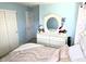 Cozy bedroom showcasing pale blue walls, teddy bears, ample storage, and a decorative dresser with mirror at 13626 Garfield St # A, Thornton, CO 80602