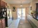 Bright kitchen with stainless steel refrigerator, granite counters, and sliding door access to the backyard at 13626 Garfield St # A, Thornton, CO 80602