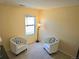 Quiet sitting room featuring carpet, neutral colored walls, a window with blinds, and two comfy chairs at 13626 Garfield St # A, Thornton, CO 80602