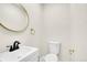 Powder room features contemporary fixtures, decorative mirror and neutral paint palette at 1448 Newport St, Denver, CO 80220