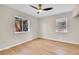 Cozy bedroom features wood-look floors, neutral walls, two windows offering ample natural light, and a ceiling fan at 1448 Newport St, Denver, CO 80220