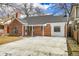 Charming brick home with modern windows and a freshly paved driveway, complemented by mature trees at 1448 Newport St, Denver, CO 80220