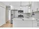 Updated kitchen boasts stainless steel appliances, white cabinetry, stylish countertops, and modern pendant lighting at 1448 Newport St, Denver, CO 80220