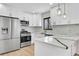 Bright kitchen features white cabinets, stainless steel appliances, modern countertops, and eye-catching pendant lights at 1448 Newport St, Denver, CO 80220