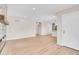 Spacious living room with light hardwood floors, neutral walls, and open access to other areas at 1448 Newport St, Denver, CO 80220
