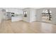 Open concept living space with hardwood floors, showcasing a modern kitchen and large windows at 1448 Newport St, Denver, CO 80220