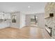 Bright living area with hardwood floors, connected to a modern kitchen and featuring a stone fireplace at 1448 Newport St, Denver, CO 80220