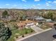 Aerial view of the property showcasing the house, landscaping, and surrounding neighborhood with mountain views at 2009 S Zephyr Ct, Lakewood, CO 80227