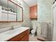Bathroom with classic design, featuring floral wallpaper, light fixtures and a modern shower at 2009 S Zephyr Ct, Lakewood, CO 80227