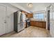 This kitchen features stainless steel appliances, wood cabinets, tile flooring, and a stacked washer and dryer at 2009 S Zephyr Ct, Lakewood, CO 80227