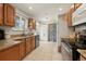 Well-lit kitchen featuring granite countertops, wooden cabinets, stainless steel appliances, and tile flooring at 2009 S Zephyr Ct, Lakewood, CO 80227