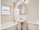 Clean bathroom with a pedestal sink, shower/tub combo, and tiled walls at 4981 E Cornell Ave, Denver, CO 80222