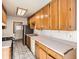 Kitchen boasts wood cabinets, white countertops, and tile flooring at 4981 E Cornell Ave, Denver, CO 80222