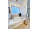 Bright bathroom with a soaking tub, decorative plant, and a separate shower stall at 26032 E Geddes Cir, Aurora, CO 80016