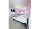 Bright bedroom with a modern bed, pink walls, and a television mounted on the wall at 26032 E Geddes Cir, Aurora, CO 80016