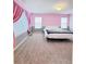 Bedroom with pink walls, grey trim, neutral carpet and simple furniture at 26032 E Geddes Cir, Aurora, CO 80016