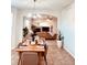 An open-concept dining room features a wooden table and view into the living room at 26032 E Geddes Cir, Aurora, CO 80016