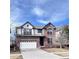 Charming two-story home with a brick and white exterior, attached two car garage and a beautifully paved driveway at 26032 E Geddes Cir, Aurora, CO 80016