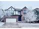 Charming two-story brick home with a well-maintained lawn and a two-car garage covered in fresh snow at 26032 E Geddes Cir, Aurora, CO 80016