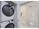 Bathroom with stacked washer/dryer and tiled floors, featuring a modern sink and toilet at 3500 S Corona St # 407, Englewood, CO 80113