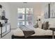 Bright bedroom with large window, gray and white color scheme, decorative pillows, and modern furnishings at 3500 S Corona St # 407, Englewood, CO 80113
