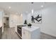 Stylish kitchen island with modern lighting, stainless appliances, and sleek white cabinetry at 3500 S Corona St # 407, Englewood, CO 80113