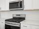 Bright kitchen features stainless steel appliances and subway tile backsplash at 1937 S Coolidge Way, Aurora, CO 80018