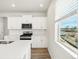 Bright kitchen with white cabinets, stainless steel appliances, an island, and a scenic view, perfect for preparing meals at 1937 S Coolidge Way, Aurora, CO 80018